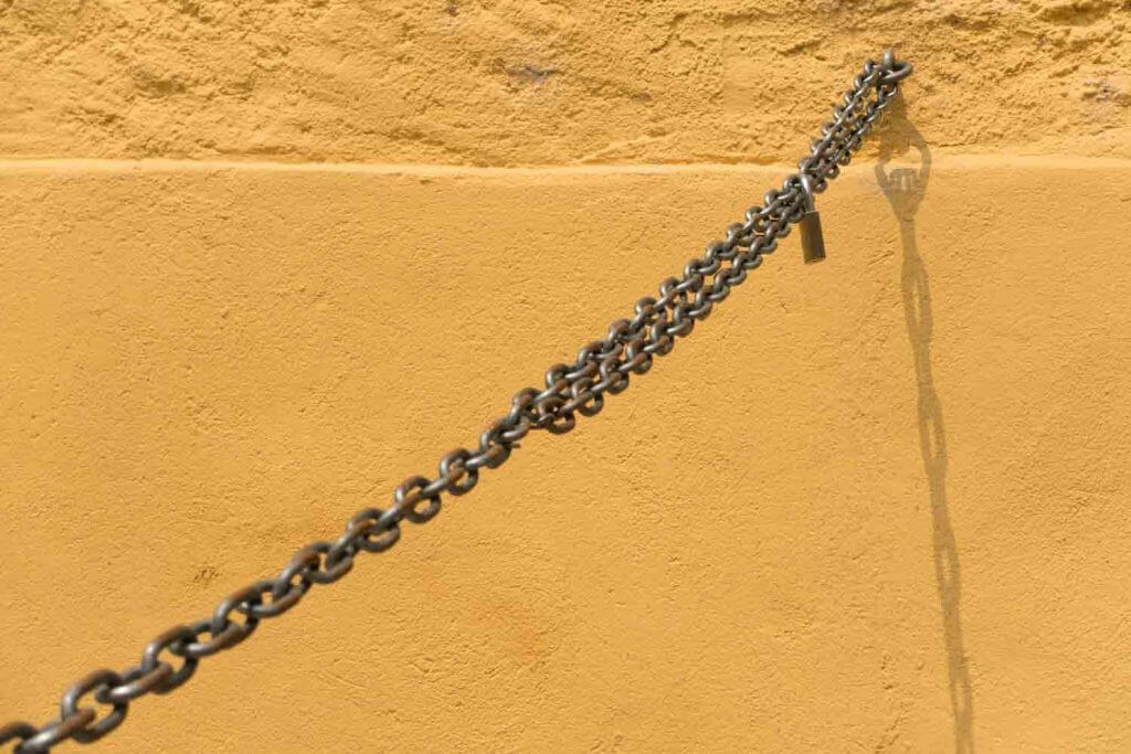 Kette an oranger Mauer in der Altstadt von Locarno - Monochrome Farben