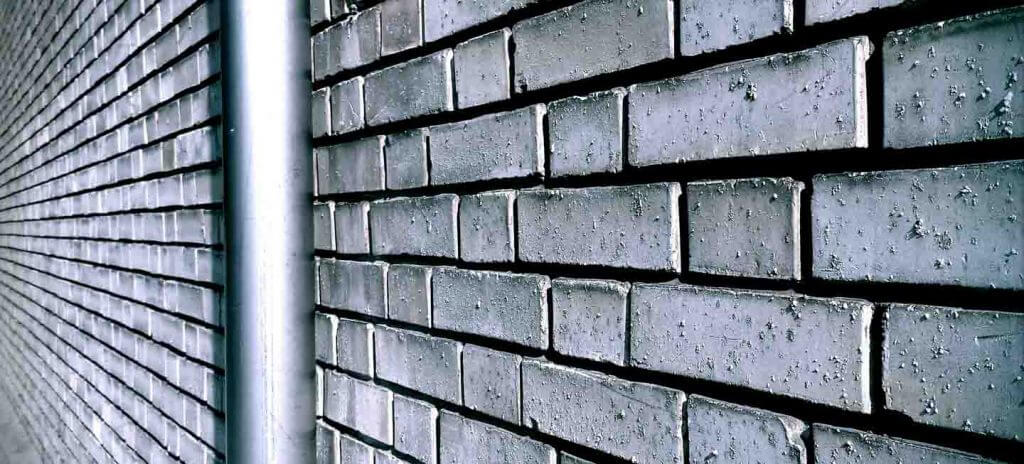 Backsteinmauer mit Regenrinne - Retrofotografie