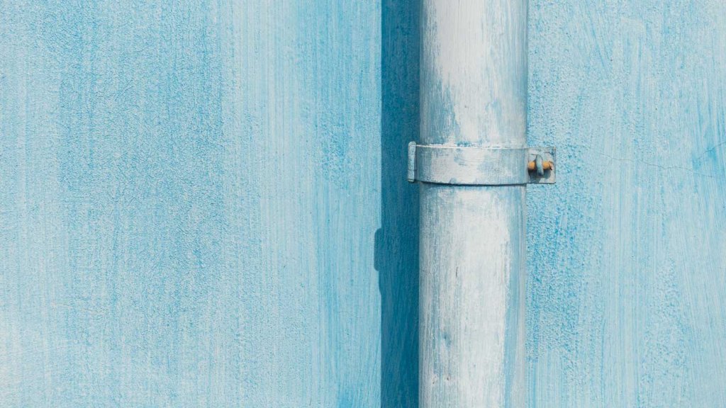 Strukturen fotografieren - hellblaue Fassade mit Regenrinne