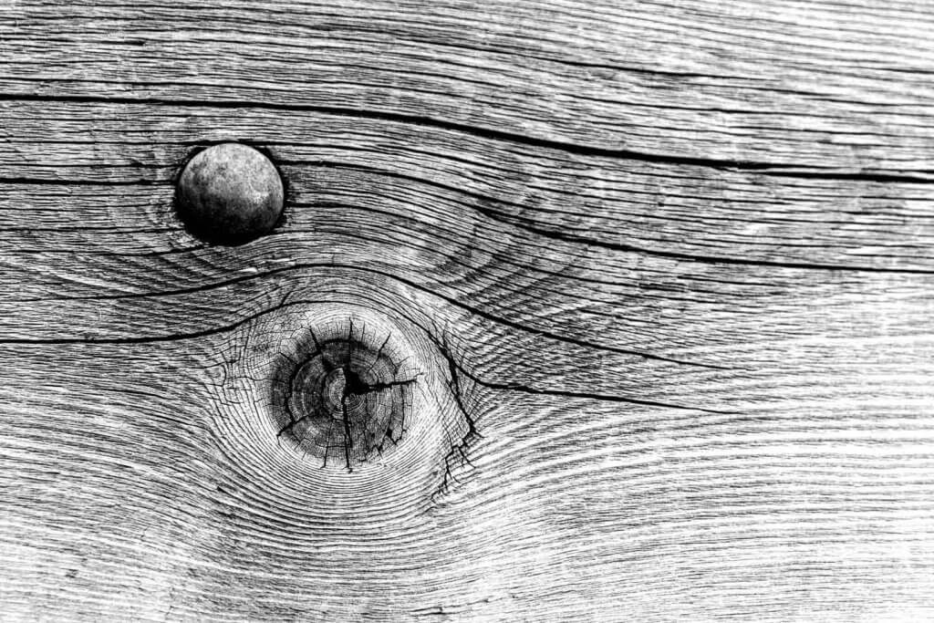 Holzstruktur und Maserung wirken in Schwarzweiss besonders plastisch Holzstruktur mit Astloch und feiner Maserung als Detailaufnahme in der Schwarzweissfotografie.