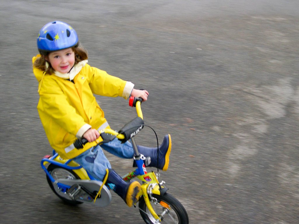 Schnappschuss eines Kindes auf dem Fahrrad mit sichtbarer Bewegung Kind auf einem Fahrrad während einer spontanen Schnappschussaufnahme