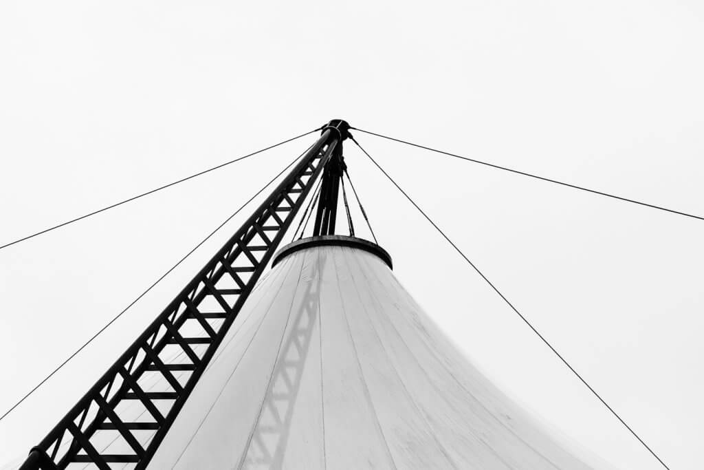 Moderne Zeltarchitektur in Schwarzweiss Schwarzweissfoto einer modernen Zeltkonstruktion mit Mast, Seilen und klaren geometrischen Linien.